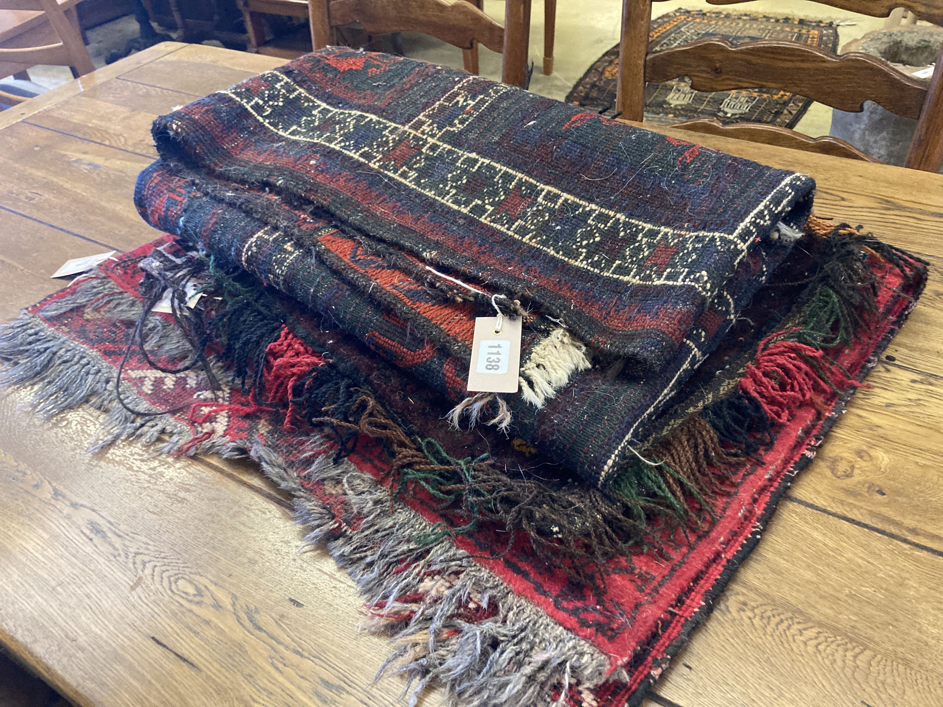 An Afghan red ground rug with stylised mihrab and iris motifs, a small Afghan rug and three carpet panel cushion covers, largest 200 x